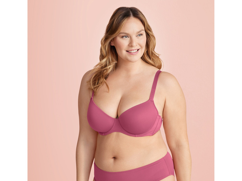 Eine Frau trägt einen rosa BH und Slip.