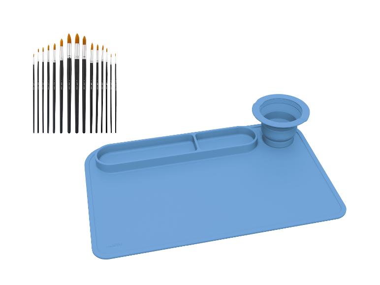 Ein Pinselset und eine blaue Silikon-Bastelmatte mit Fächern und einem faltbaren Becher.