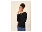 Frau in schwarzem Pullover und Jeansrock, blickt zur Seite.