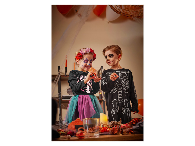 Zwei Kinder in Skelettkostümen an Halloween