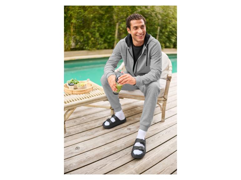 Mann sitzt am Pool mit dem CRIVIT Akku-Shaker.