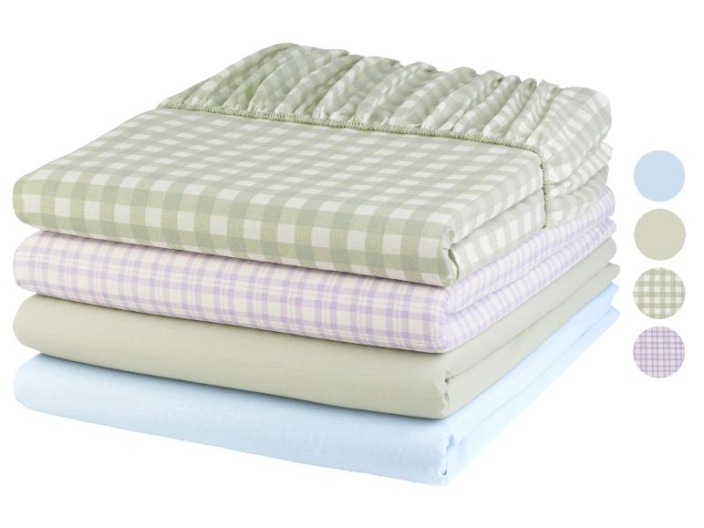 Ein Stapel Bettwäsche in grünen und lila Karos.