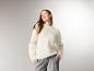 Lächelnde Frau im ESMARA® Premium-Pullover mit Mohair-Anteil und grauer Hose.
