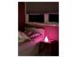 Kind schläft im Bett mit einer rosa Hasenlampe auf einem Nachttisch.
