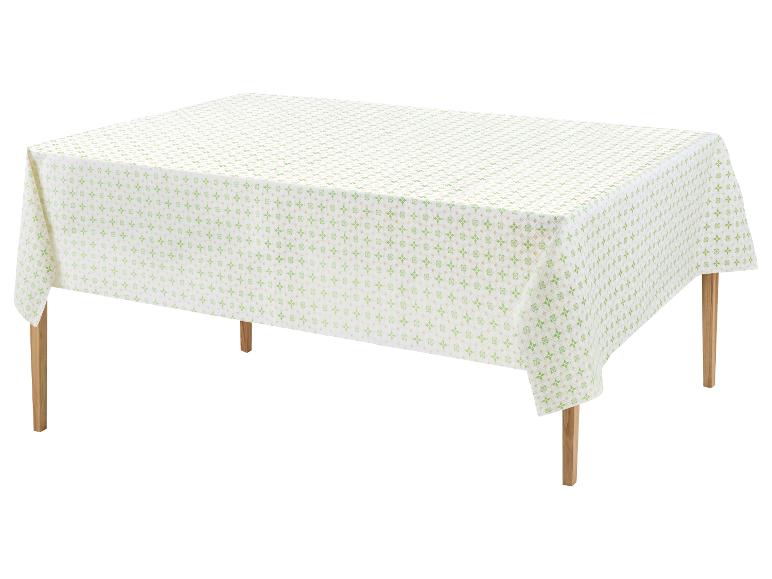Weiße Tischdecke mit grünem geometrischem Muster auf einem Holztisch.
