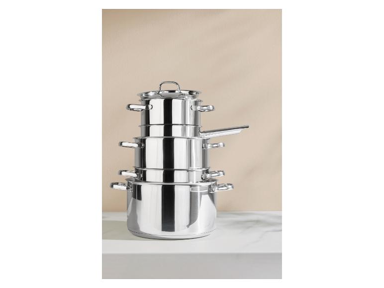 Gestapelte Edelstahltöpfe auf einer weißen Arbeitsplatte.