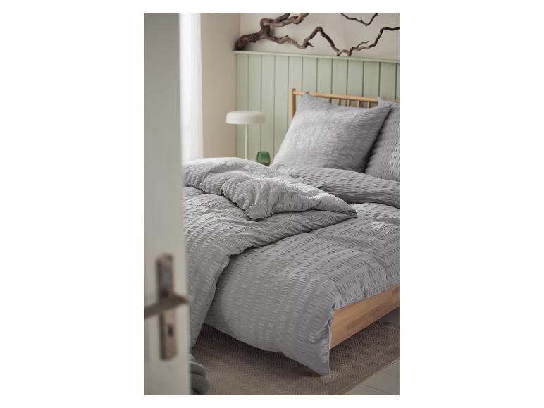 Graue, strukturierte Bettwäsche mit Bettbezug und Kissen.