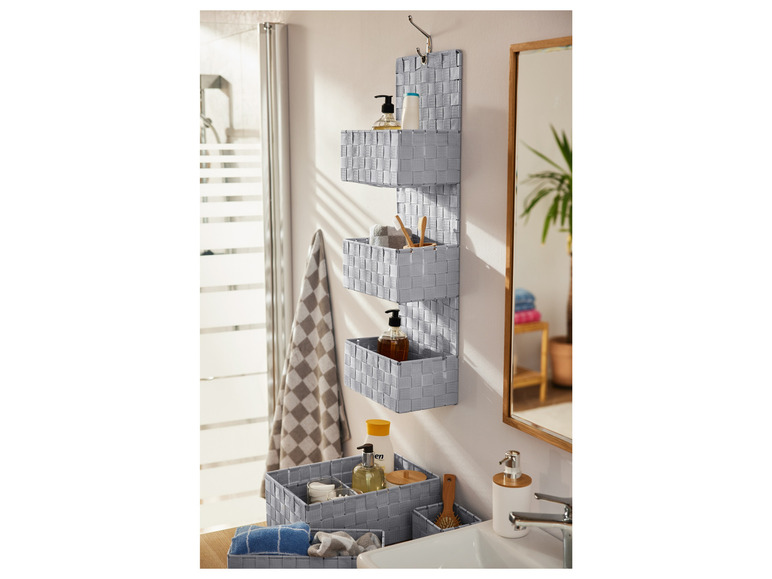 Graue Aufbewahrungskörbe mit Produkten in einem Badezimmer.