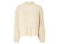 Beigefarbener Zopfmusterpullover.