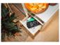 Offene Schublade mit Bürste und Kehrschaufel, daneben eine Topfpflanze und eine Schale Chips.