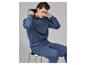 Mann im blauen STRENESSE BLUE Kapuzenpullover mit Piqué-Struktur, auf einem Hocker sitzend.