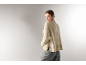 Frau von hinten in einem beigen Rollkragenpullover und einer grauen Hose.
