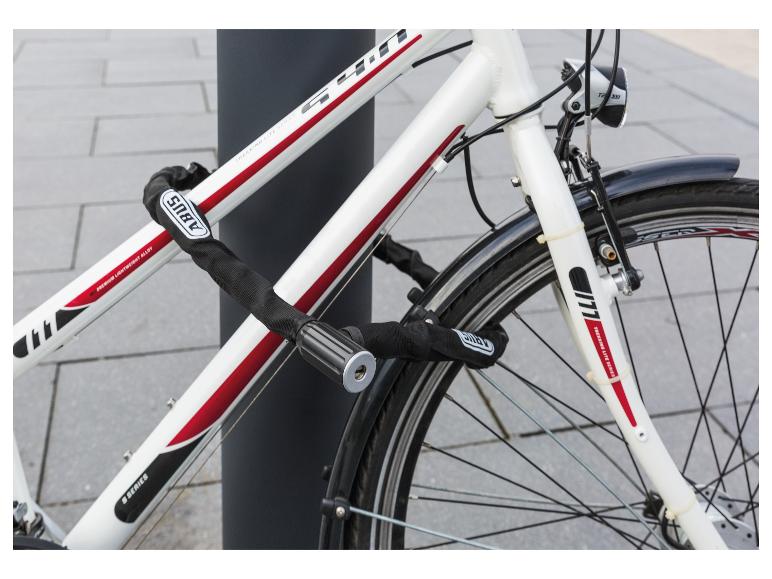 Weißes Fahrrad mit schwarzem Kettenschloss, mit den Texten 'PREMIUM LIGHTWEIGHT ALLOY' und 'TREKKING LITE SERIES'.