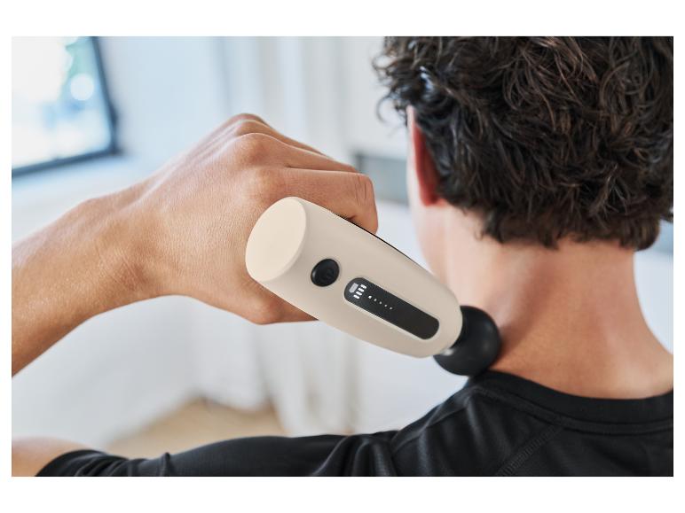 Ein Mann benutzt einen Therabody Percussion-Massagegerät, um seinen Nacken zu entspannen.