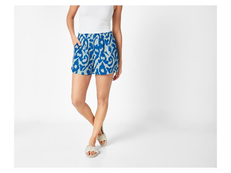 Gemusterte Shorts und flache Sandalen: Sommer-Outfit.