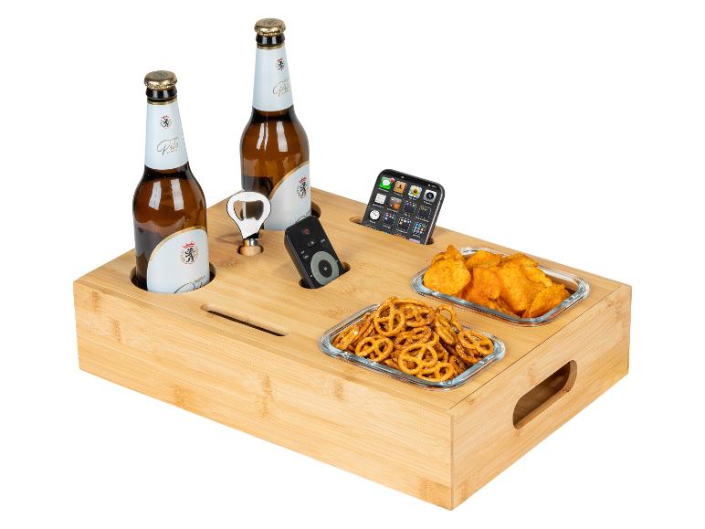 Bambus-Serviertablett mit Bierflaschen, Snacks, Flaschenöffner, Fernbedienung und Telefon.