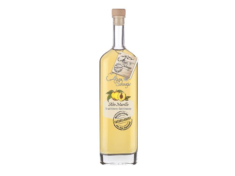 Flasche Aprikosenschnaps mit Etikett „Alpen Schnaps Alte Marille Traditions-Spirituose Meisterstücke Fassgelagert aus dem Alpenland“.
