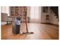 Wischmopp und Eimer mit Wringsystem in einem Wohnzimmer mit Holzboden.