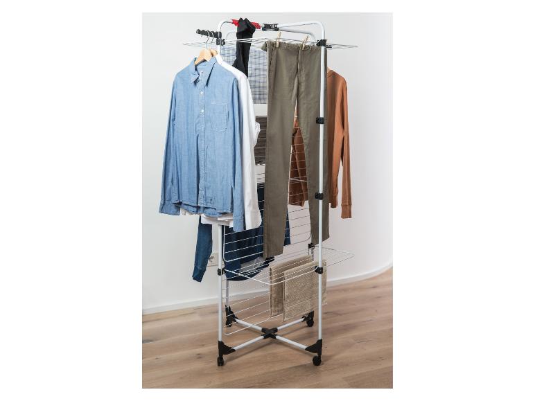 Wäscheständer mit verschiedenen Kleidungsstücken, darunter Hemden und Hosen.