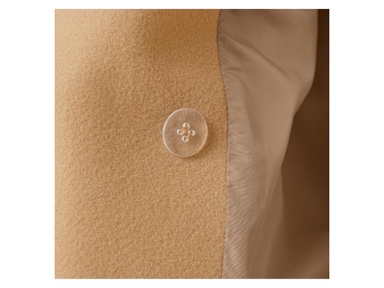 Nahaufnahme eines beigefarbenen Wollmantels mit einem Knopf