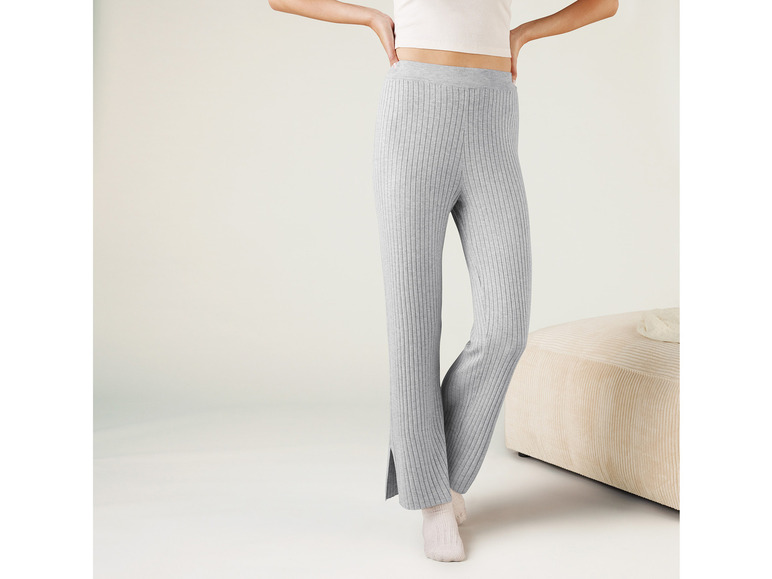Eine Frau trägt graue, gerippte Hosen mit Schlitzen.