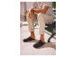 Mann in gestreiftem T-Shirt und beiger Hose sitzt auf einer Bank mit schwarzen Clogs.