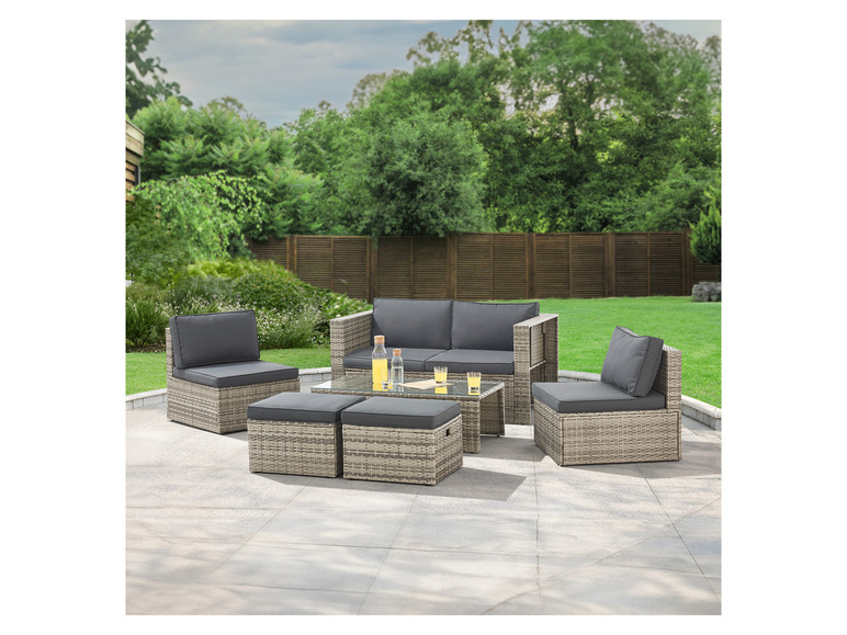 Eine graue Rattan-Lounge-Garnitur mit zwei Sesseln, einer Couch und einem Tisch.