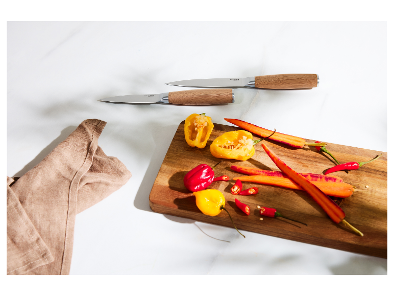 SilverCrest Küchenmesser und geschnittenes Gemüse auf einem Holzbrett.