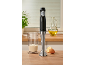 Stabmixer auf einem Holztisch neben einem Messbecher, einem Ei und einer Zitrone