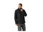 Mann in schwarzer Regenjacke und grauen Jeans, schaut zur Seite.