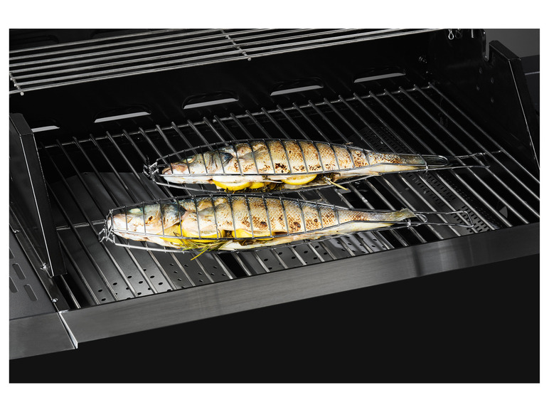 Zwei Fische werden auf einem Grill mit Zitrone und Kräutern gegrillt.