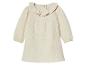 Beige Babykleid mit langen Ärmeln und Rüschenkragen.