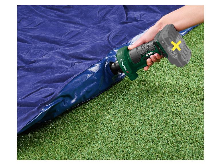 Elektrische Luftpumpe bläst eine blaue Luftmatratze auf grünem Gras auf.