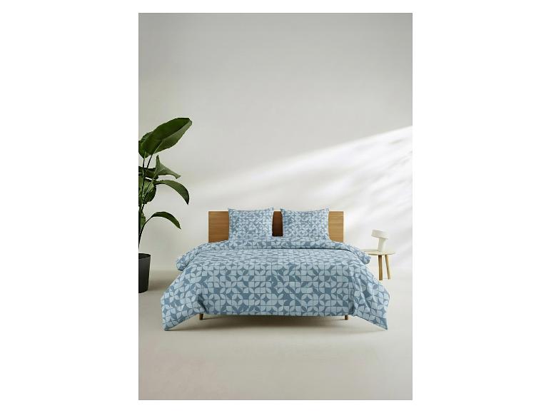 Blaues Bettwäsche-Set mit geometrischem Muster in einem minimalistischen Schlafzimmer.