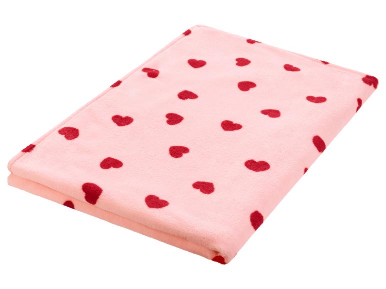 Eine rosa Fleece-Decke mit roten Herzen.