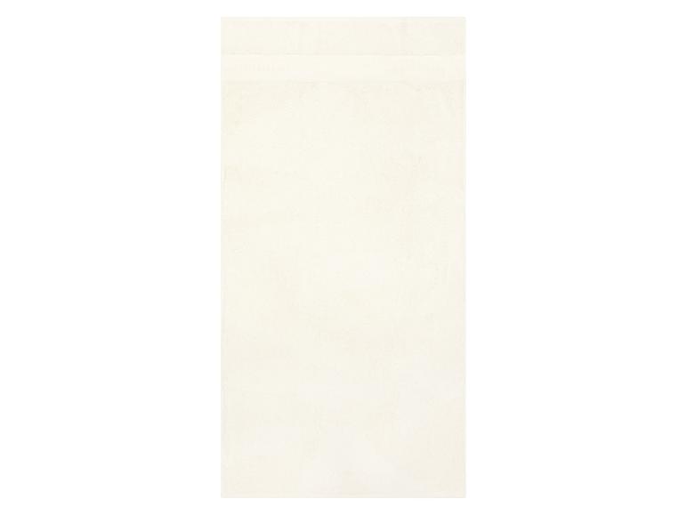 Ein schlichtes cremefarbenes Badetuch mit einem dezenten strukturierten Band am oberen Rand.
