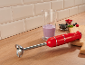 Roter Stabmixer auf Holzarbeitsplatte mit Smoothie und Beeren.