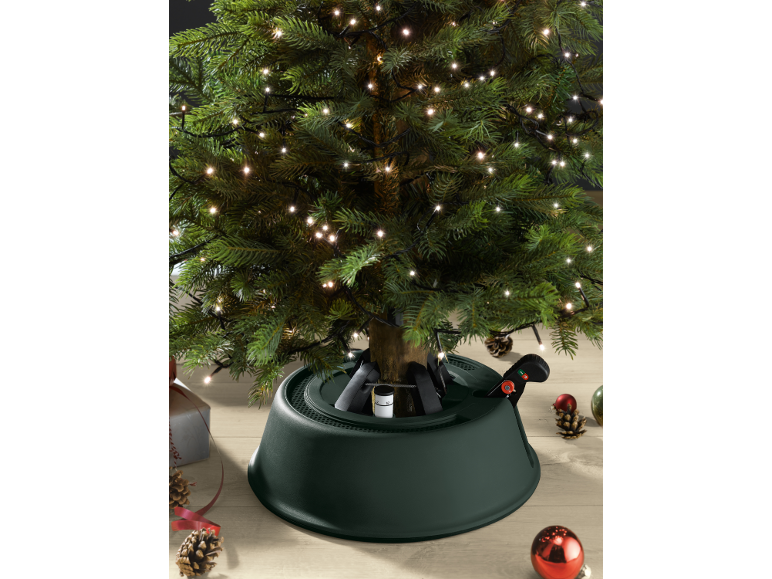 Beleuchteter künstlicher Weihnachtsbaum mit grünem Ständer und festlicher Dekoration.