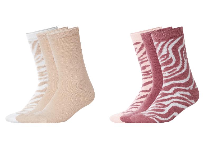 Zwei Sets Socken: beige und weiß, sowie rosa und bordeaux mit Zebramuster.