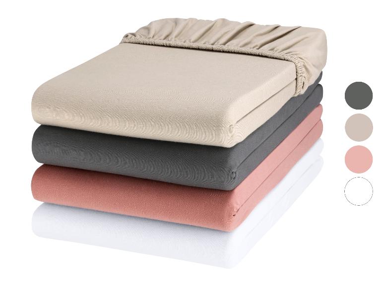 Stapel von drei Matratzenschonern in gedeckten Farben.