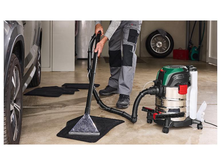 Mann reinigt Automatten mit einem Parkside Staubsauger in einer Garage.