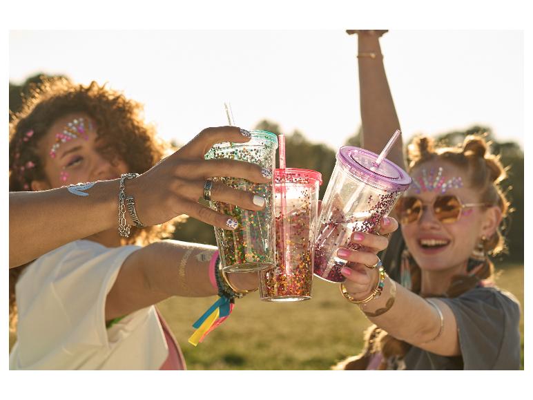 Freundinnen stoßen mit glitzernden Bechern an.
