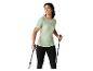Frau in hellgrünem T-Shirt und schwarzen Leggings mit Trekkingstöcken.