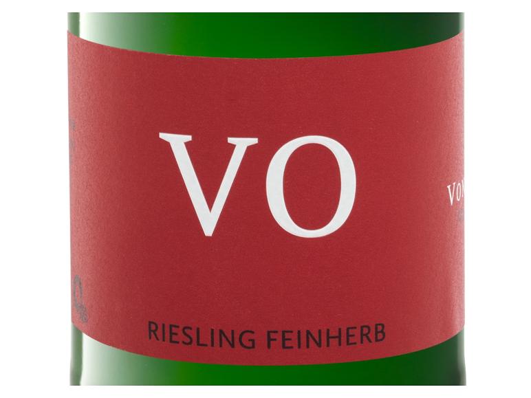 Rotes Weinetikett mit den Buchstaben „VO“ und „RIESLING FEINHERB“ auf einer grünen Flasche.