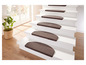Braune Treppenstufenmatten auf einer weißen Treppe.