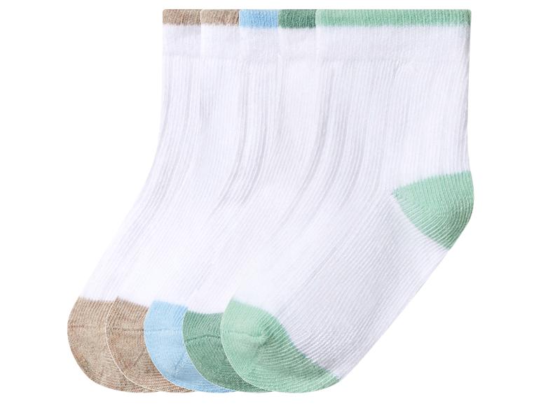 Vier Paar weiße Socken mit farbigen Fersen und Bündchen in Braun, Blau und Grün.