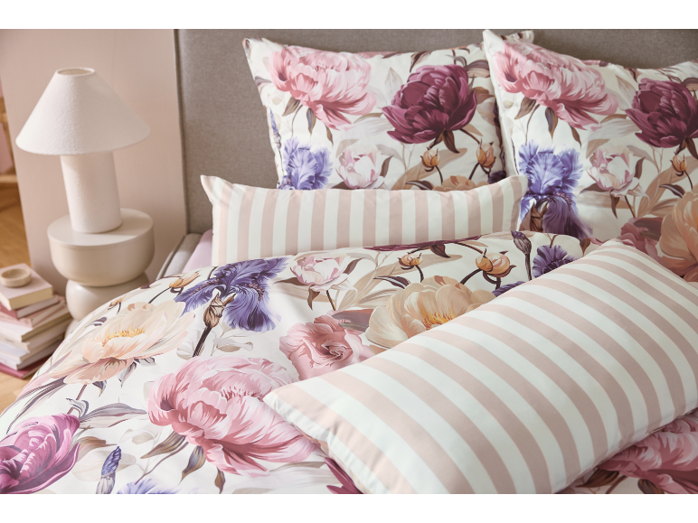 Blumenbettwäsche mit Pfingstrosen und Iris, mit rosa-weiß gestreiften Kissen.