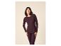 Frau lächelt in einem dunkelvioletten Langarmshirt und passenden Leggings.