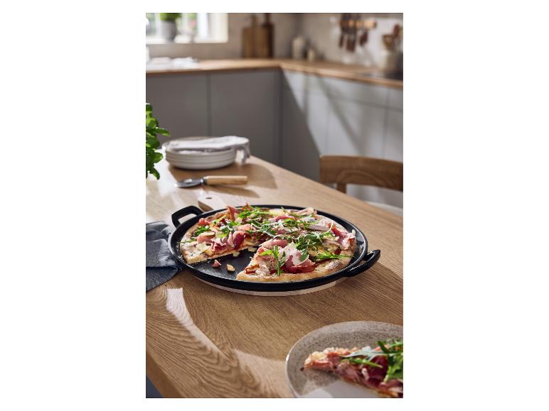 SILVERCREST® Gusseisen-Pizzaplatte mit frisch gebackener Pizza auf einem Holztisch