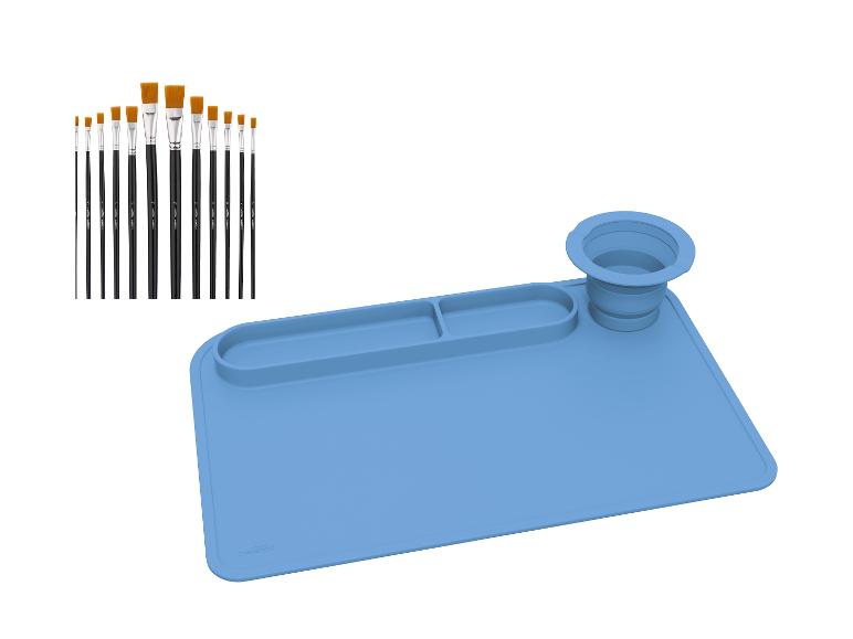 Ein Pinselset und eine blaue Silikon-Kunstmatte mit Fächern und einem faltbaren Becher.
